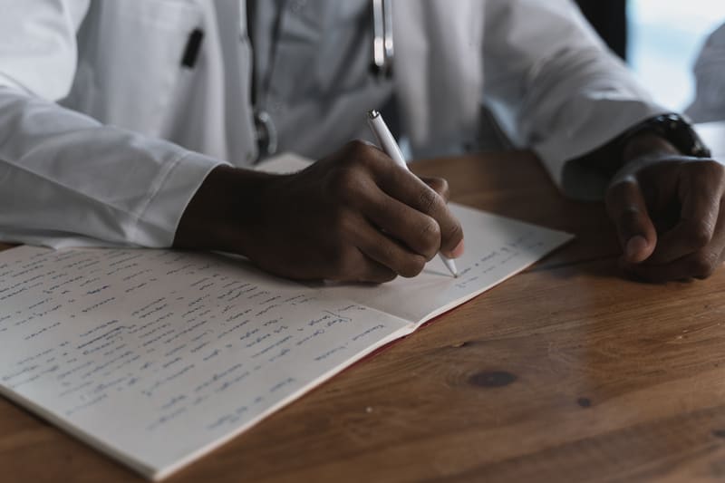 Healthcare professional carefully writing notes by hand