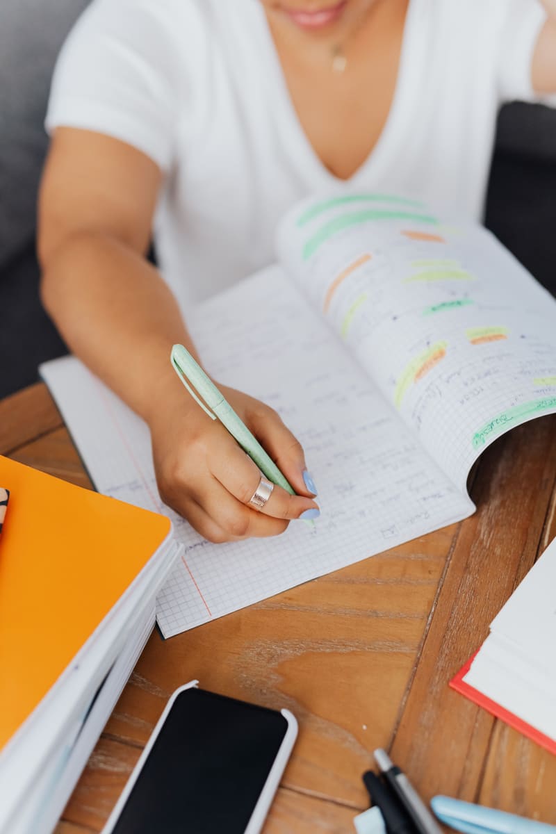 Student highlighting notes during exam preparation